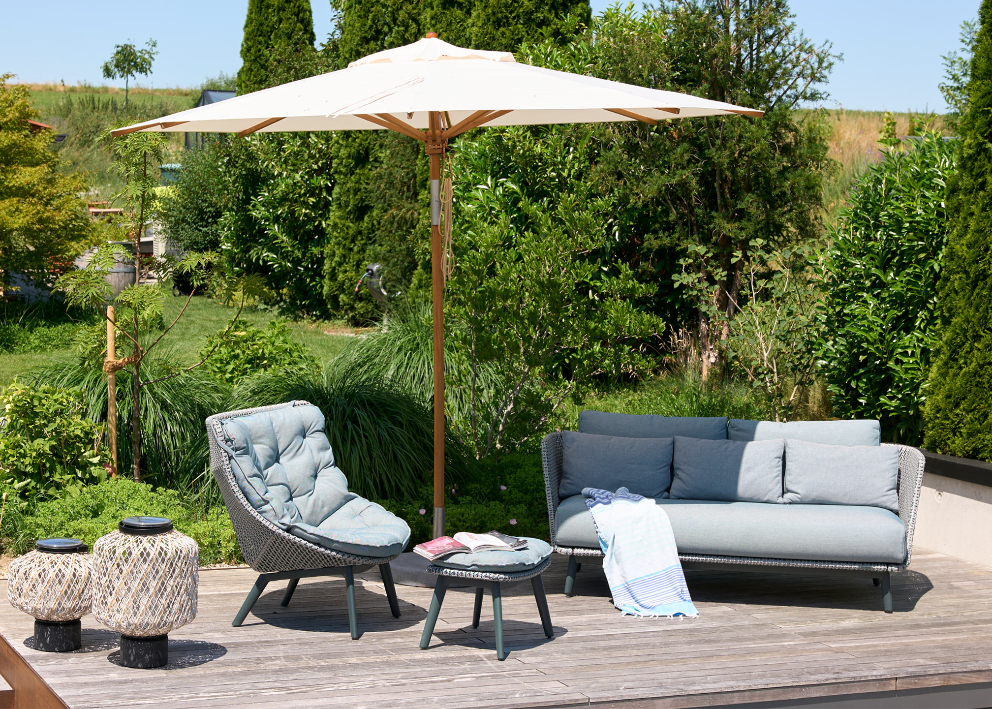 Terrasse mit The Others Leuchten, Sessel MBrace Alu mit Hocker, Sonnenschirm Teak von Weishäupl und Sofa MBarq von Dedon
